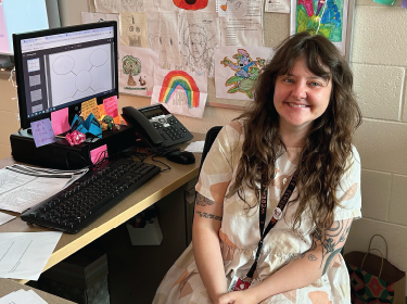 woman sitting at desk smiling